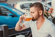 Good looking man drinking beer in street cafe