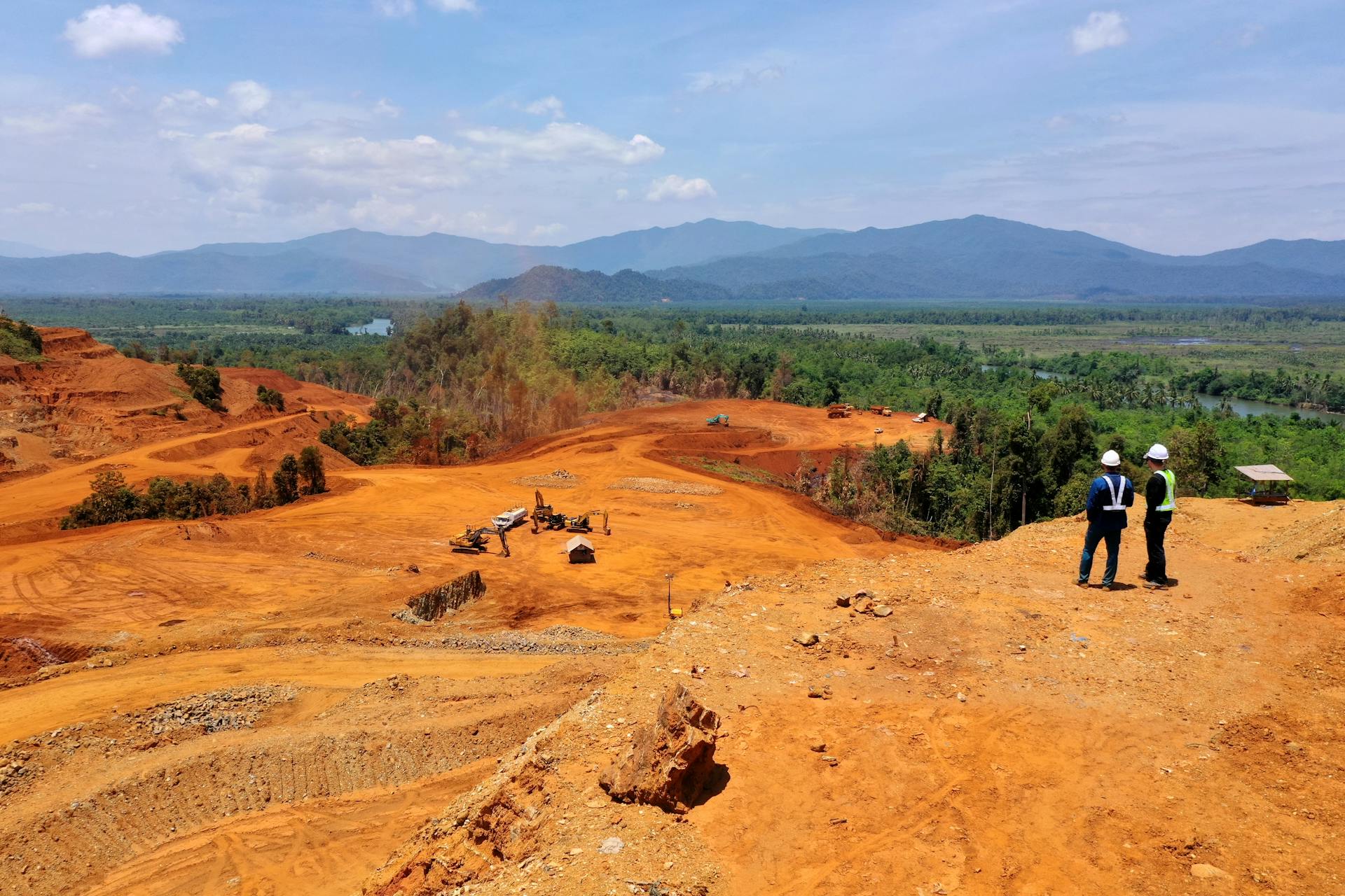 Expansive view of a mining area in Molawe, Sulawesi, with workers and machinery.