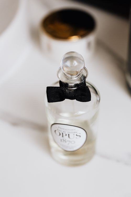 Free Stylish vertical shot of a clear glass perfume bottle decorated with a black ribbon, showcasing elegance and sophistication. Stock Photo