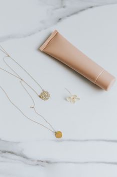 大理石表面时尚地陈列着黄金珠宝与化妆品管，是优雅品牌的理想之选