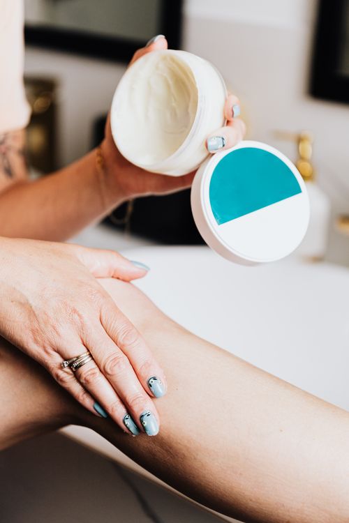 Free Close-up of a woman using lotion on her leg for skin care with manicured nails. Stock Photo