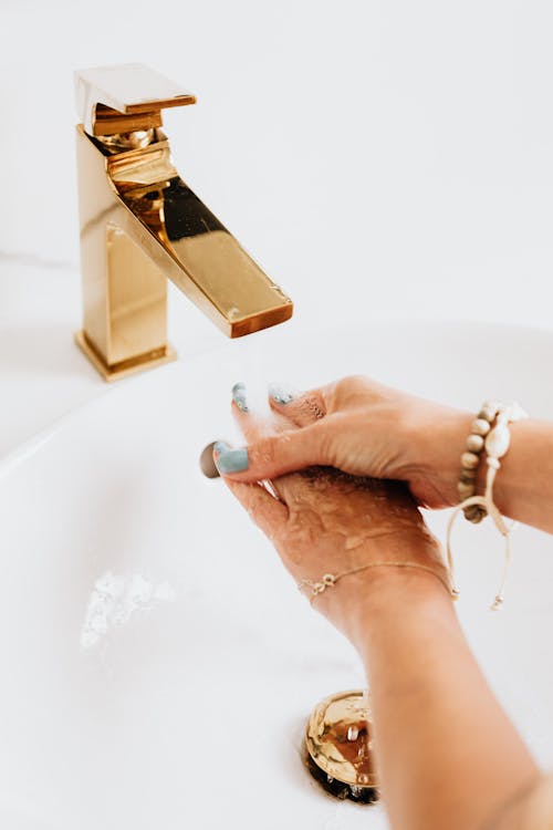 Free  Woman Washing Hands on a Golden Faucet  Stock Photo