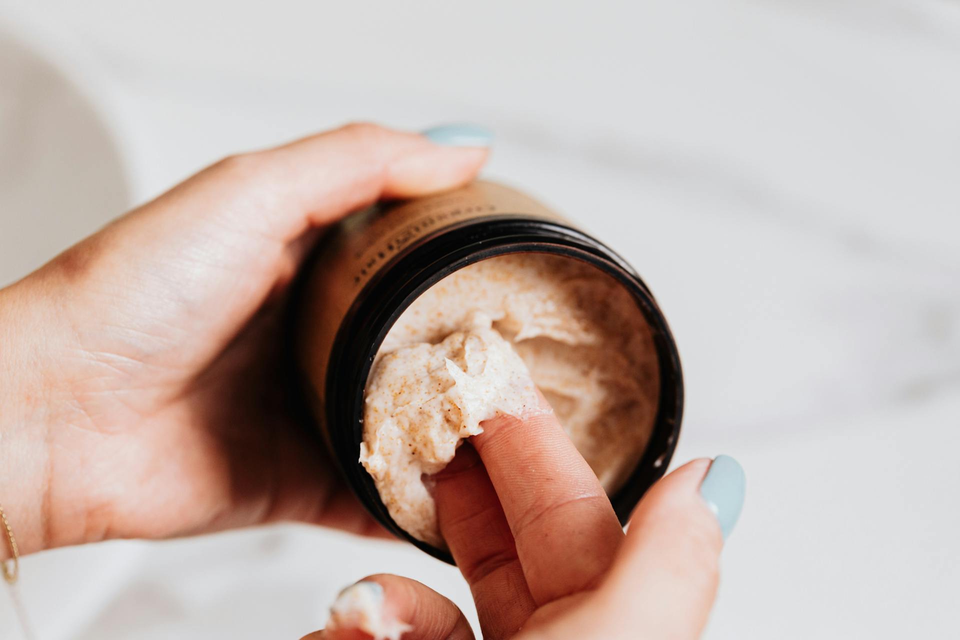 Close-up of Woman Taking Cream from a Container