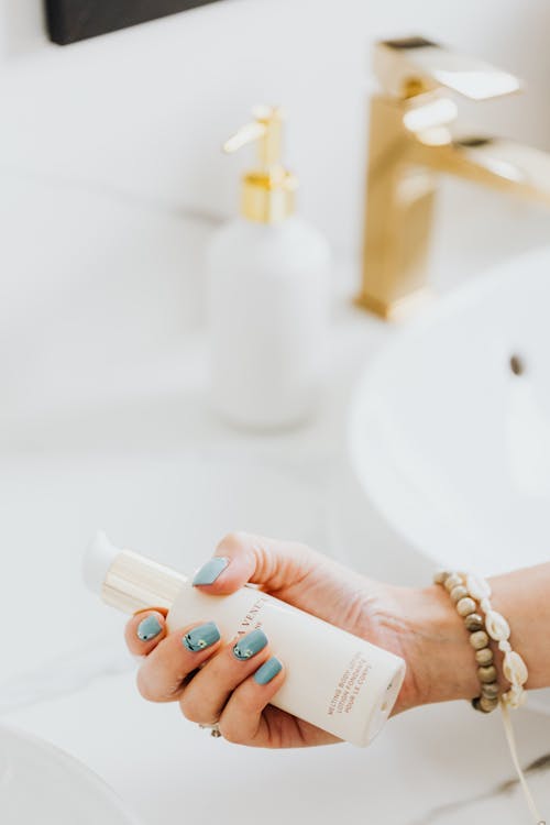 Close-up of Woman Holding a Bottle with a Cosmetic Product 