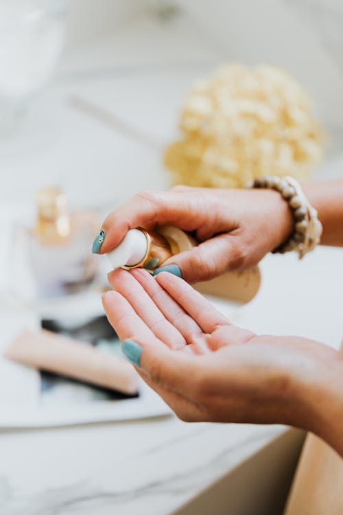 Close-up of Woman Putting a Cosmetic Product on Her Hand 