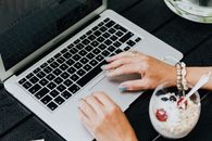 Person Using Macbook Pro on Black Table