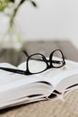 Black Framed Eyeglasses on White Book Page