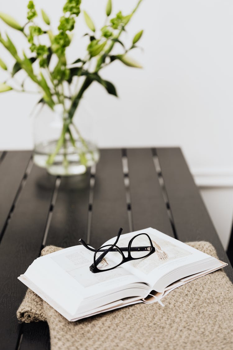 Black Framed Eyeglasses On White Book Page