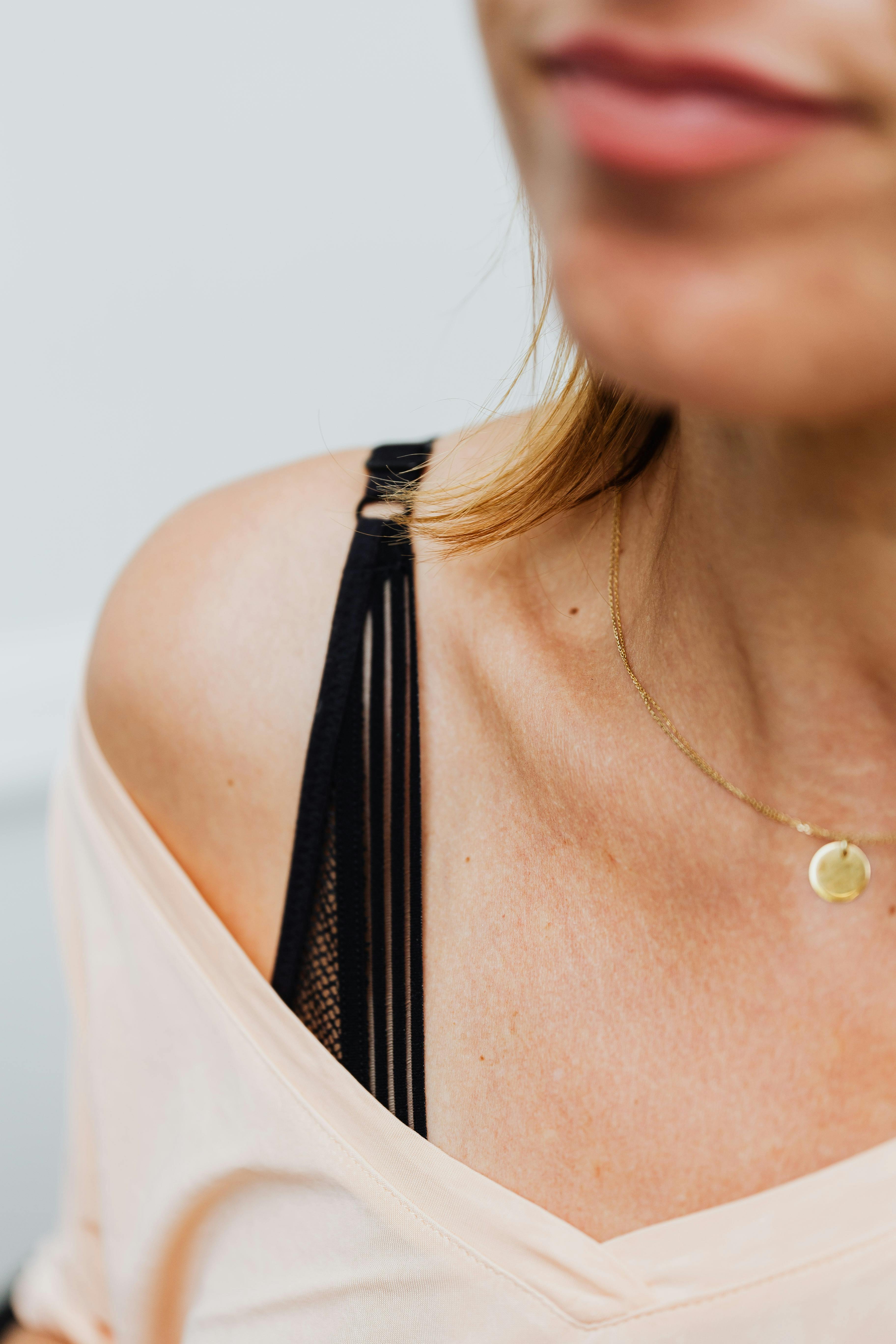 close up of woman wearing a gold necklace