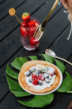 A delectable serving of pancakes topped with fresh berries and cream, perfect for breakfast or brunch.