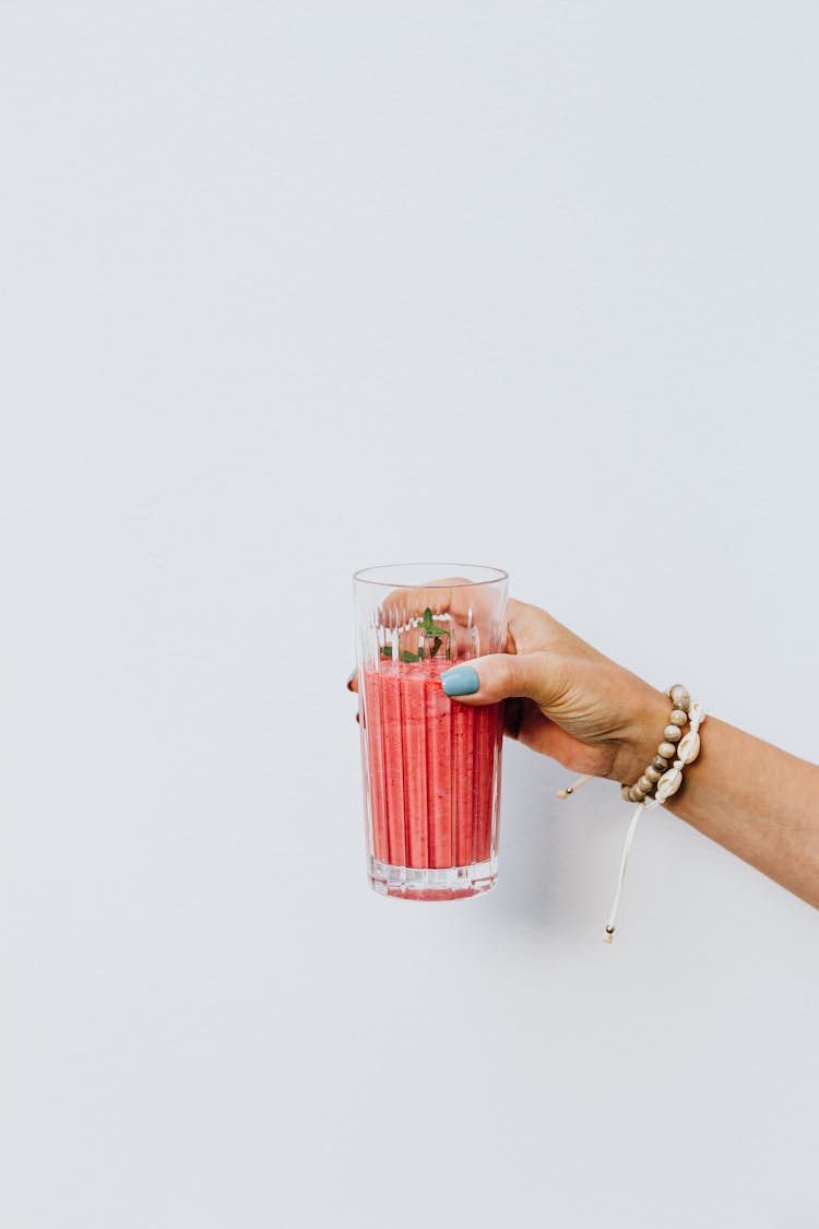 Woman Holding A Pink Smoothie In A Glass