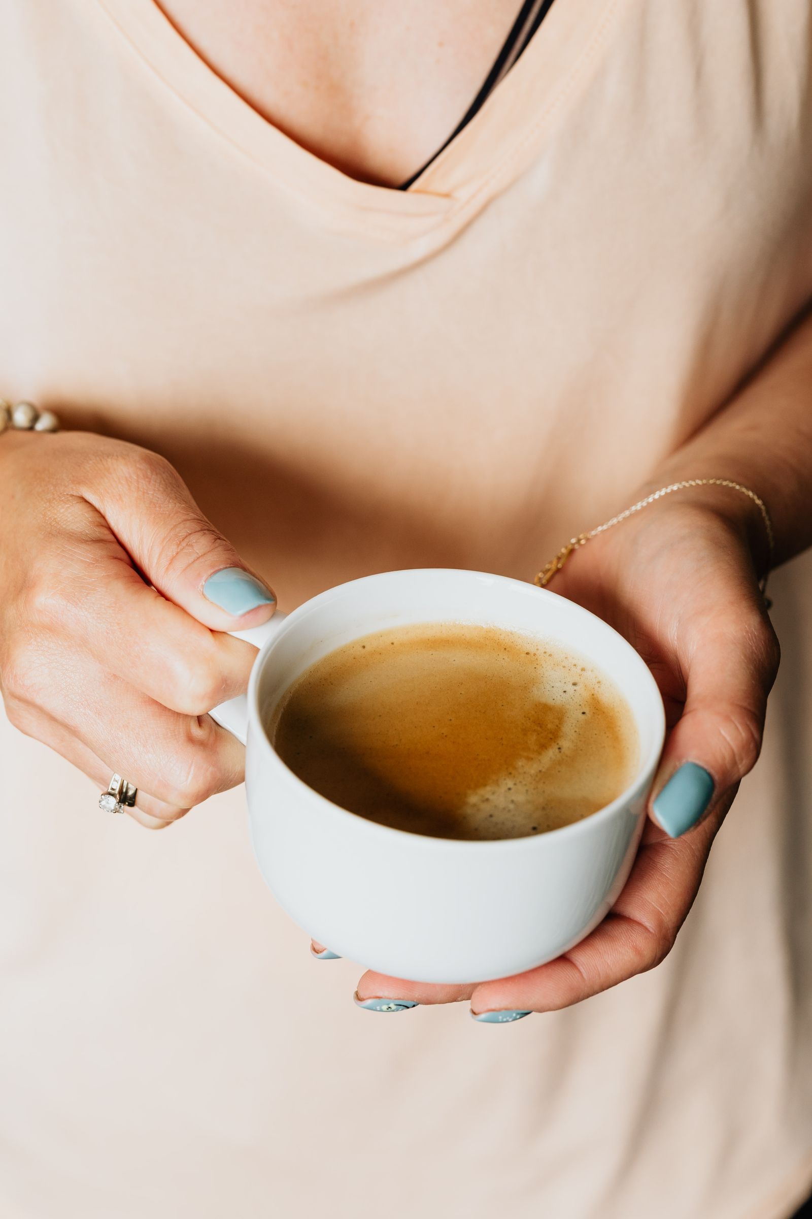 A calm morning at the kitchen table, coffee in both hands