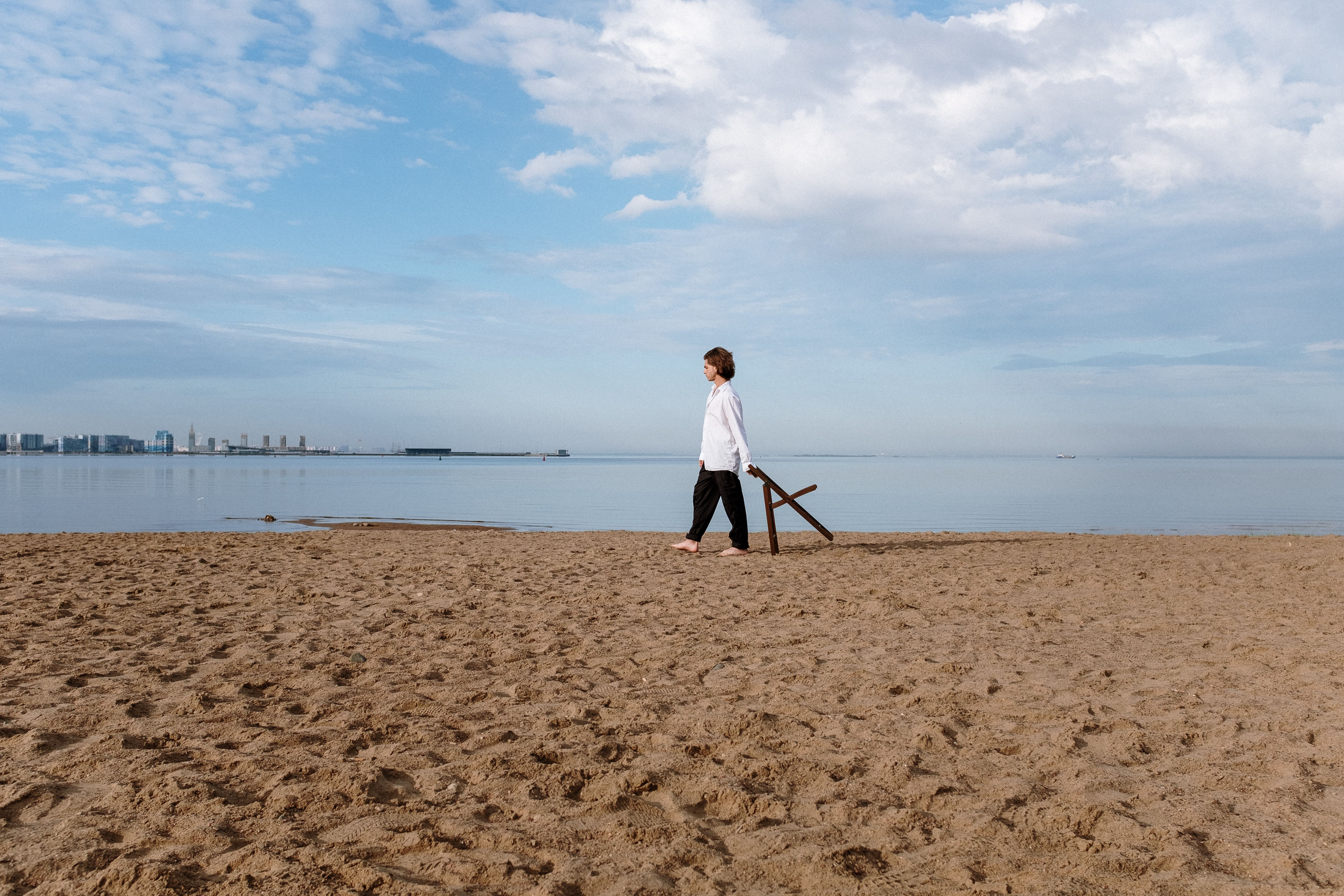 Woman in White Long Sleeve Shirt Standing on Beach · Free Stock Photo