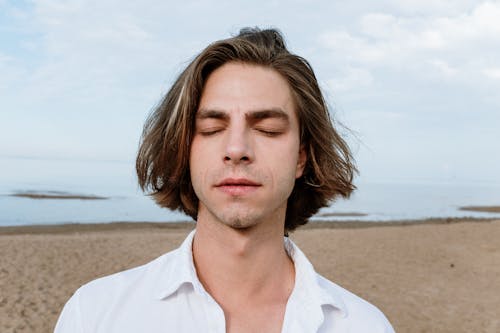 Man in White Button Up Shirt Standing on Beach