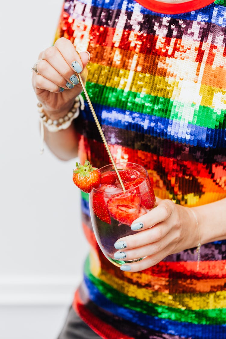 Person Holding A Glass Of Sangria With Strawberries 