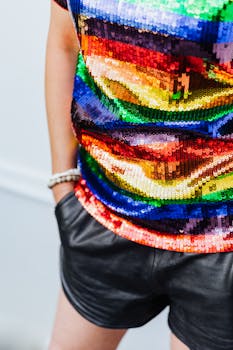 Vibrant sequined shirt paired with chic black leather shorts and a bracelet.