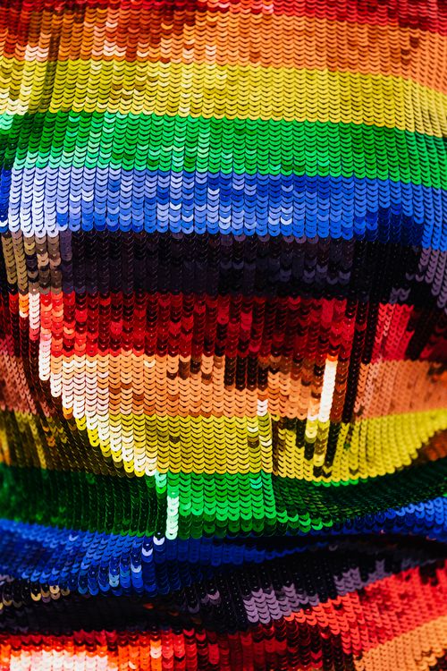 Free Colorful sequins in rainbow hues create a vibrant abstract texture, ideal for fashion and design themes. Stock Photo