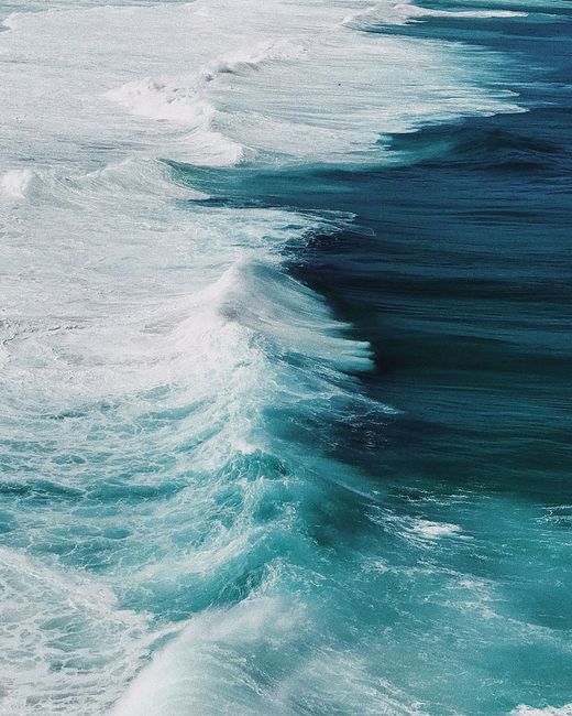 Stunning aerial view of turquoise ocean waves crashing on Arraial do Cabo beach.