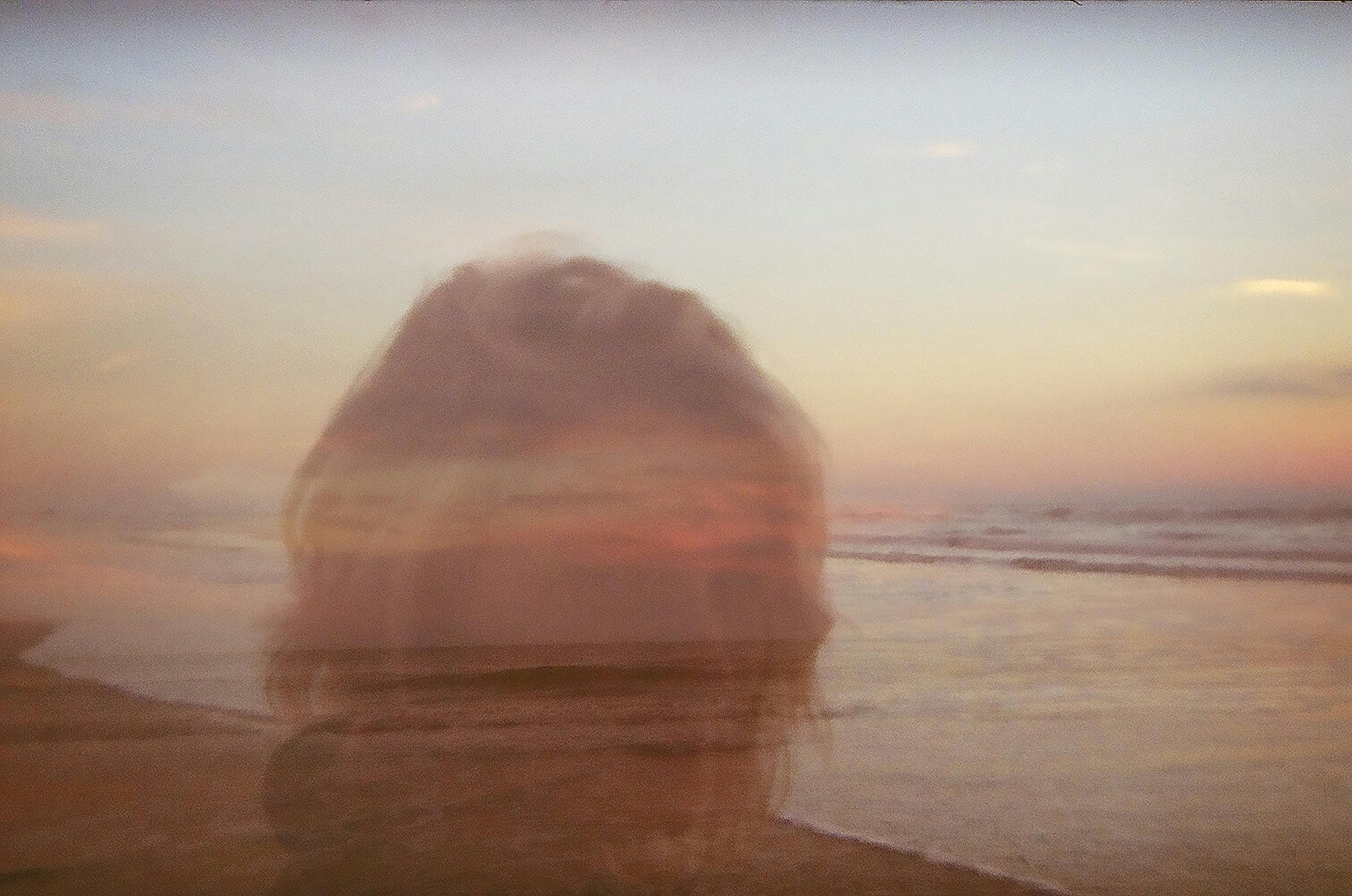 Ethereal double exposure of a woman over the serene Xangri-lá coastline during sunset.