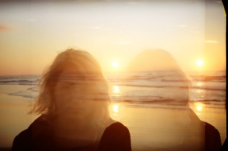 A Triple Exposure Photo Of A Woman And An Ocean At Sunset