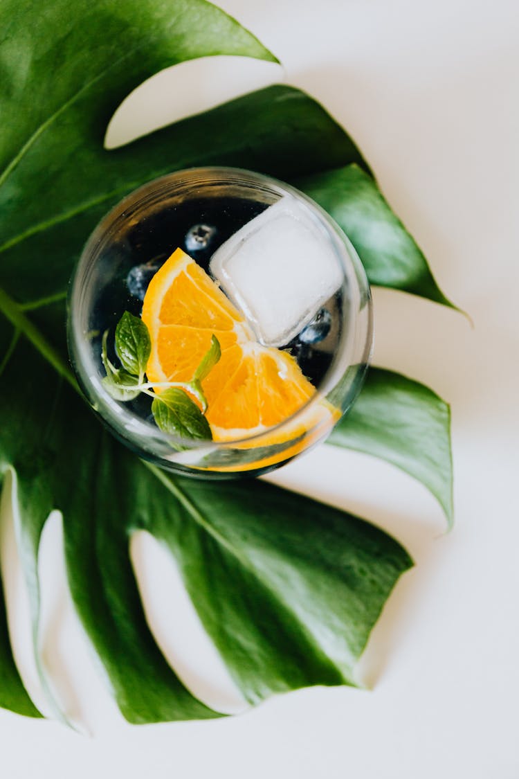 A Slice Of Orange Fruit On Clear Glass With Mint Leaves And Ice Cube