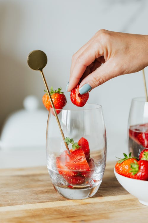 Free A Person Holding Red Strawberry on Top of a Glass Stock Photo