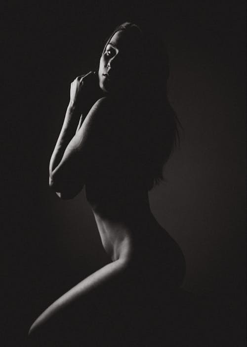 Naked woman in dark studio