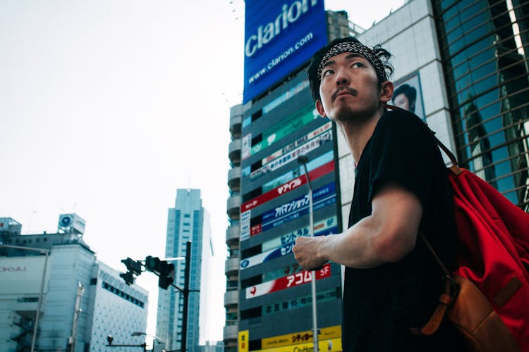 Asian Man With Backpack On Street