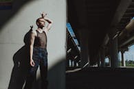 Man in Blue Denim Jeans Standing Beside White Wall
