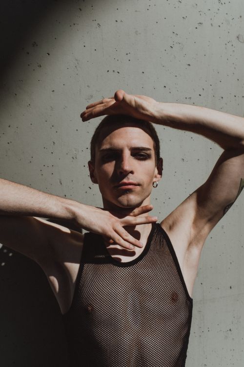 Free A striking portrait of a male dancer in a mesh top showcasing vogue dance style. Stock Photo
