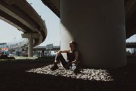 Man in White T-shirt Sitting on Ground