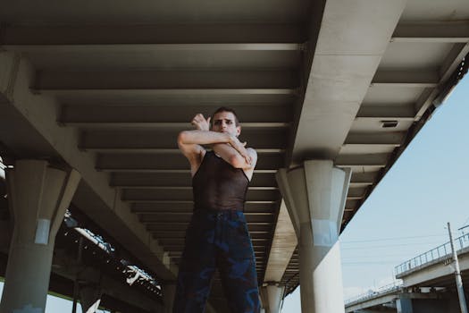 现代城市桥下，男性街头舞者摆出时尚的姿势