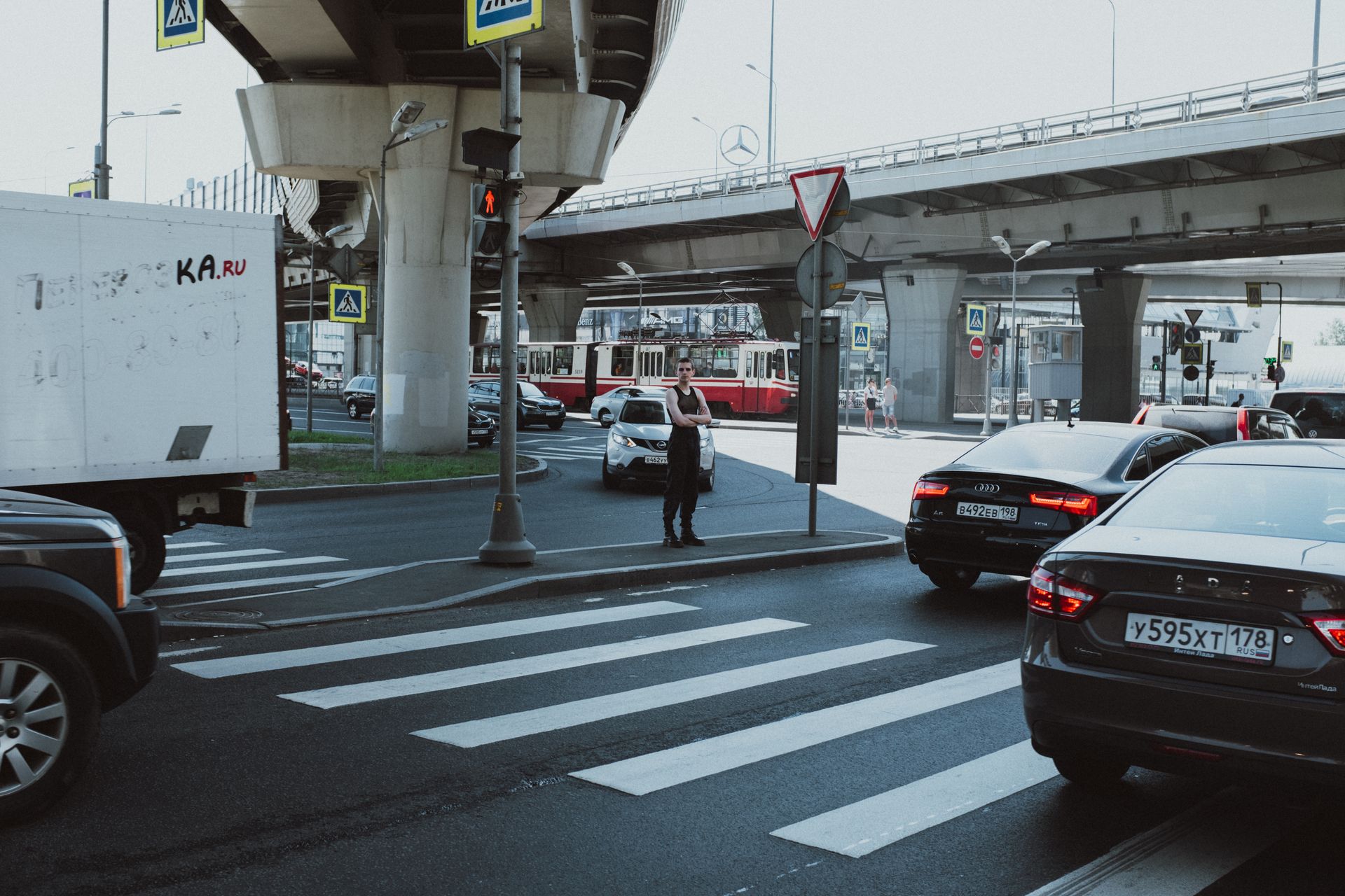City intersection with moving vehicles and pedestrian in an urban setting.