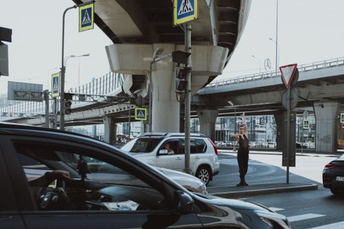 Free A vibrant city scene featuring a dancer amidst traffic under an urban overpass. Stock Photo