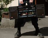 Man in Black Leather Boots Holding Black and Red Radio