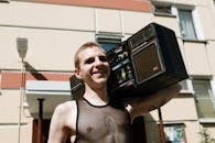 Man in Black Tank Top Wearing Eyeglasses Sitting on Chair