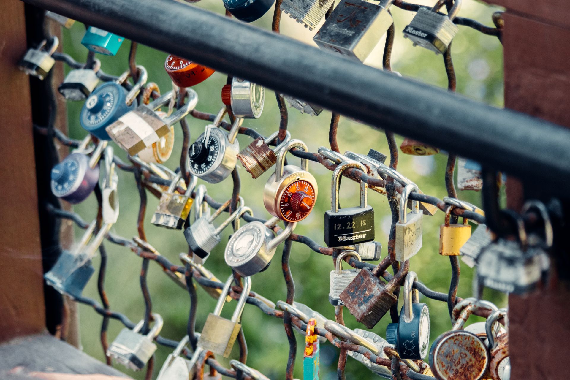 Colorful padlocks attached to a fence symbolize promises and love.