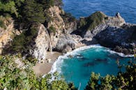 在阳光明媚的日子里，从上面俯瞰，绿松石泻湖被岩石悬崖和瀑布环绕，景色壮丽