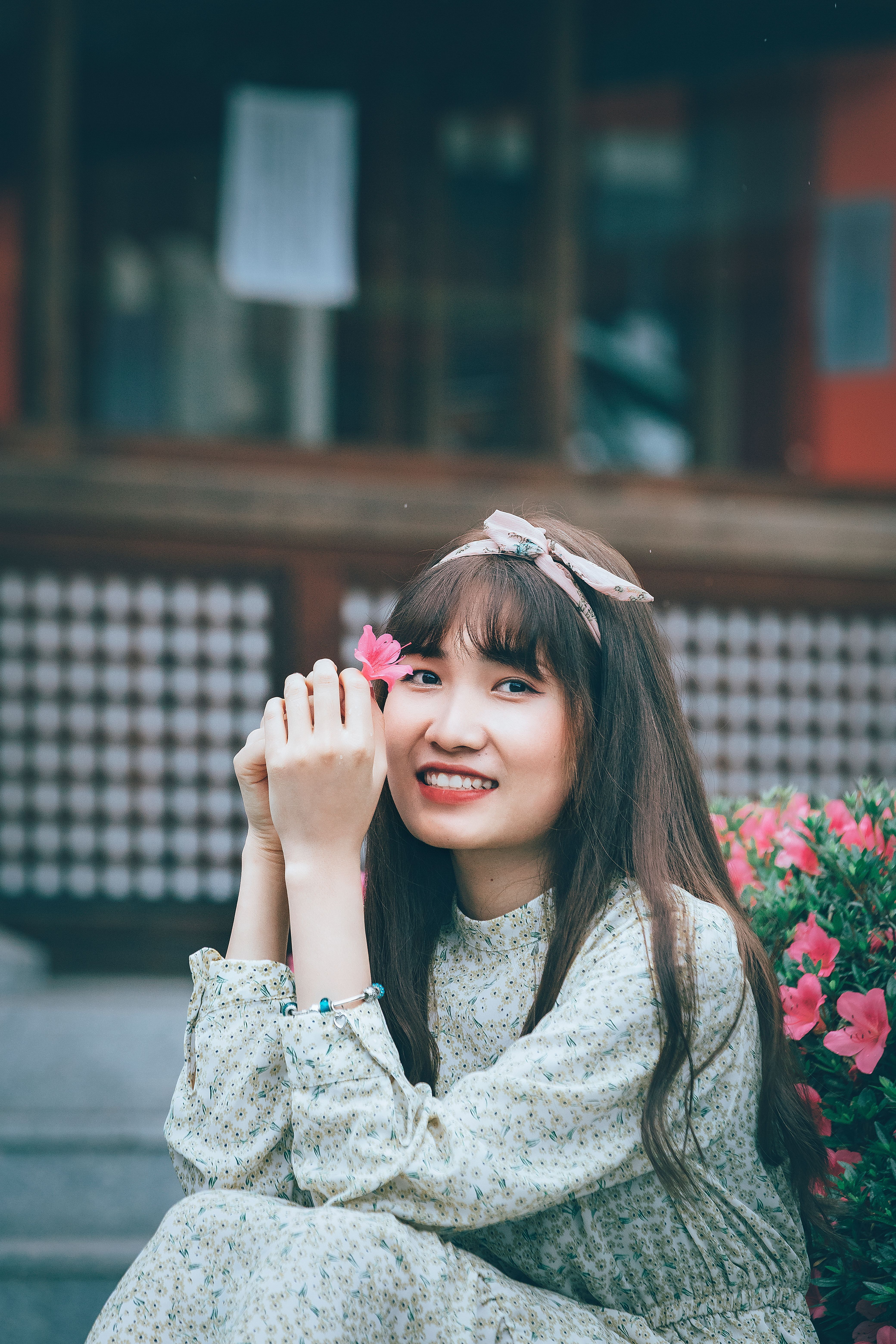 穿着花连衣裙的女人在户外鲜花丛中微笑