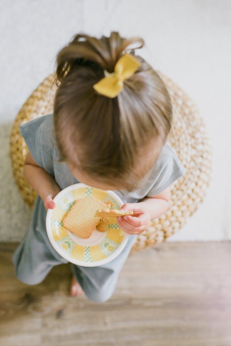 Unrecognizable Girl Eating Crunchy Biscuit At Home