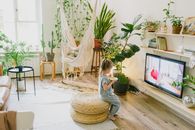 Girl in White Long Sleeve Shirt Sitting on Brown Wicker Chair