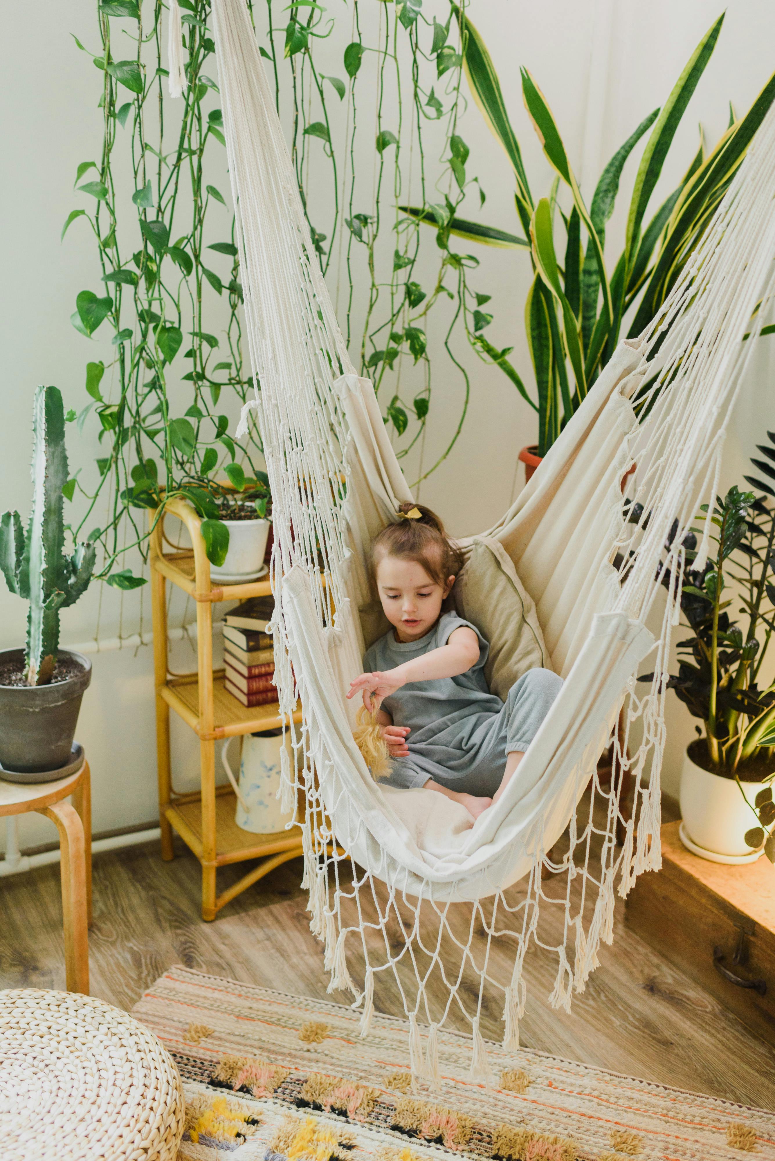 little child playing in hammock at home