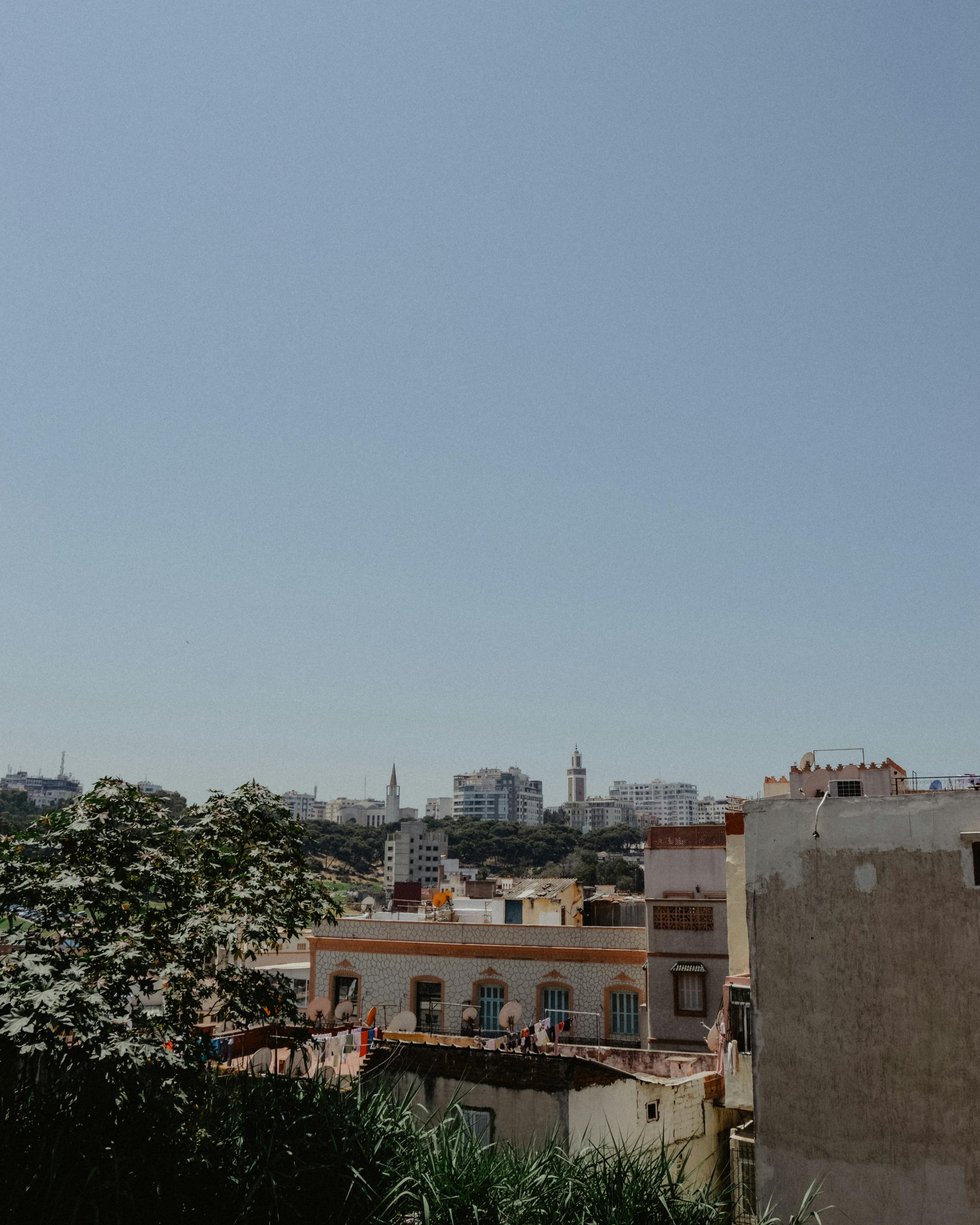 Explore the urban skyline and architectural beauty of Tangier, Morocco under a clear blue sky.