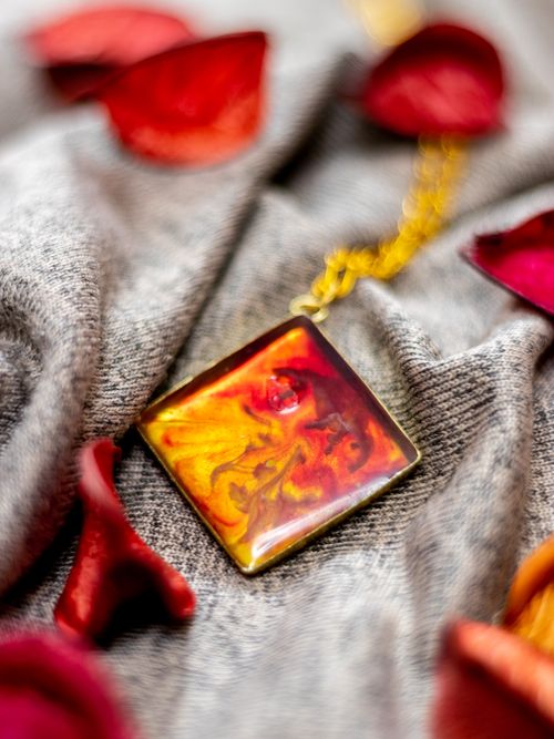 Free Artistic close-up of an amber necklace adorned with vibrant rose petals in soft focus. Stock Photo