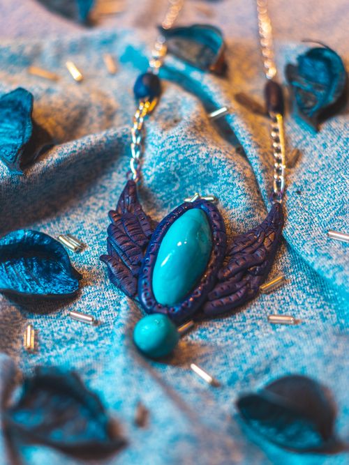Free Close-up of a handcrafted blue stone necklace on textured fabric with clay and beads. Stock Photo
