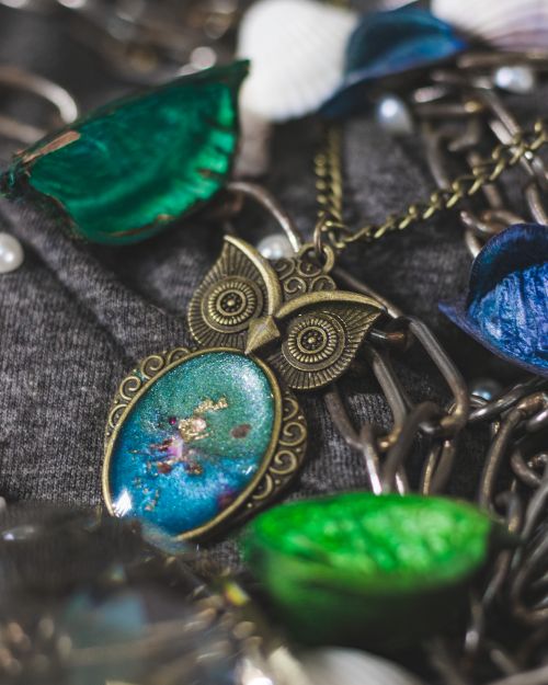 Free Close-up of a beautifully crafted owl pendant necklace with intricate details and vibrant colors. Stock Photo