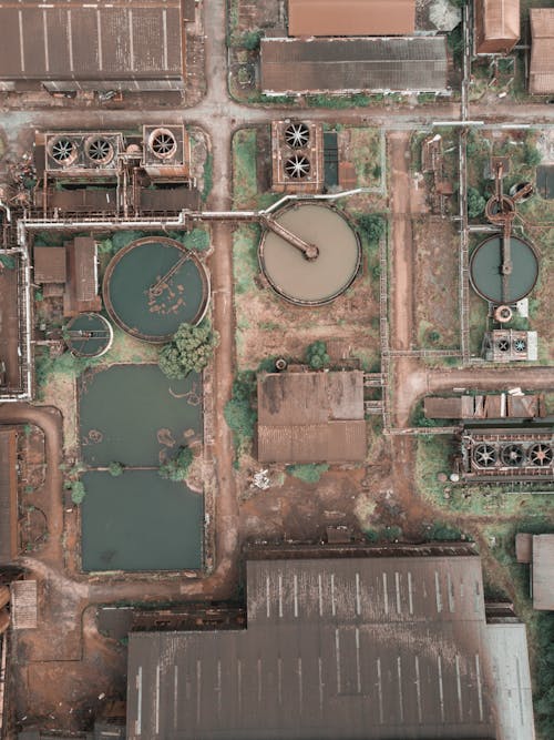 From above aerial view of industrial area of sewage treatment plant with round shaped water clarifiers