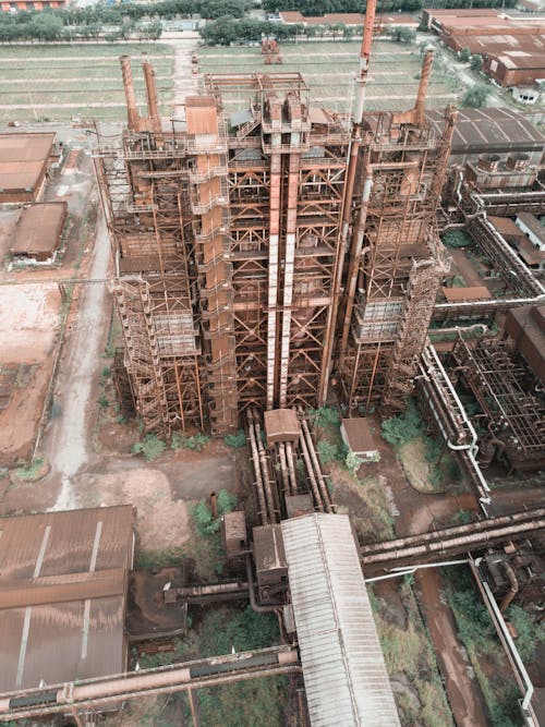 Drone view of industrial area of old plant with metal rusty constructions and pipes