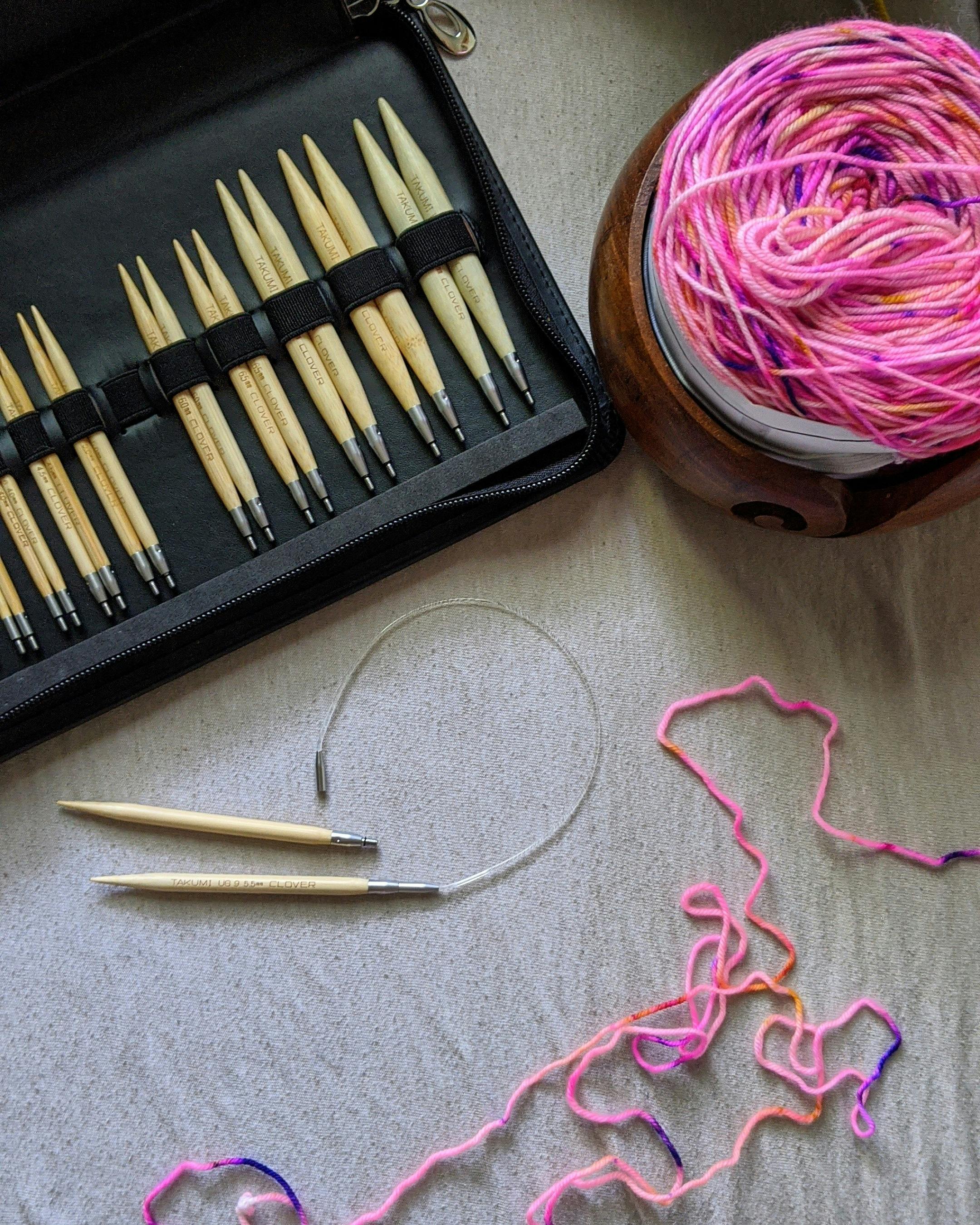 A flat lay of knitting tools with vibrant yarn, perfect for needlework hobbies.