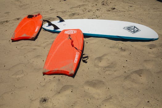 Colorful surfboards and bodyboards resting on the sandy beach of Santa Barbara, California.